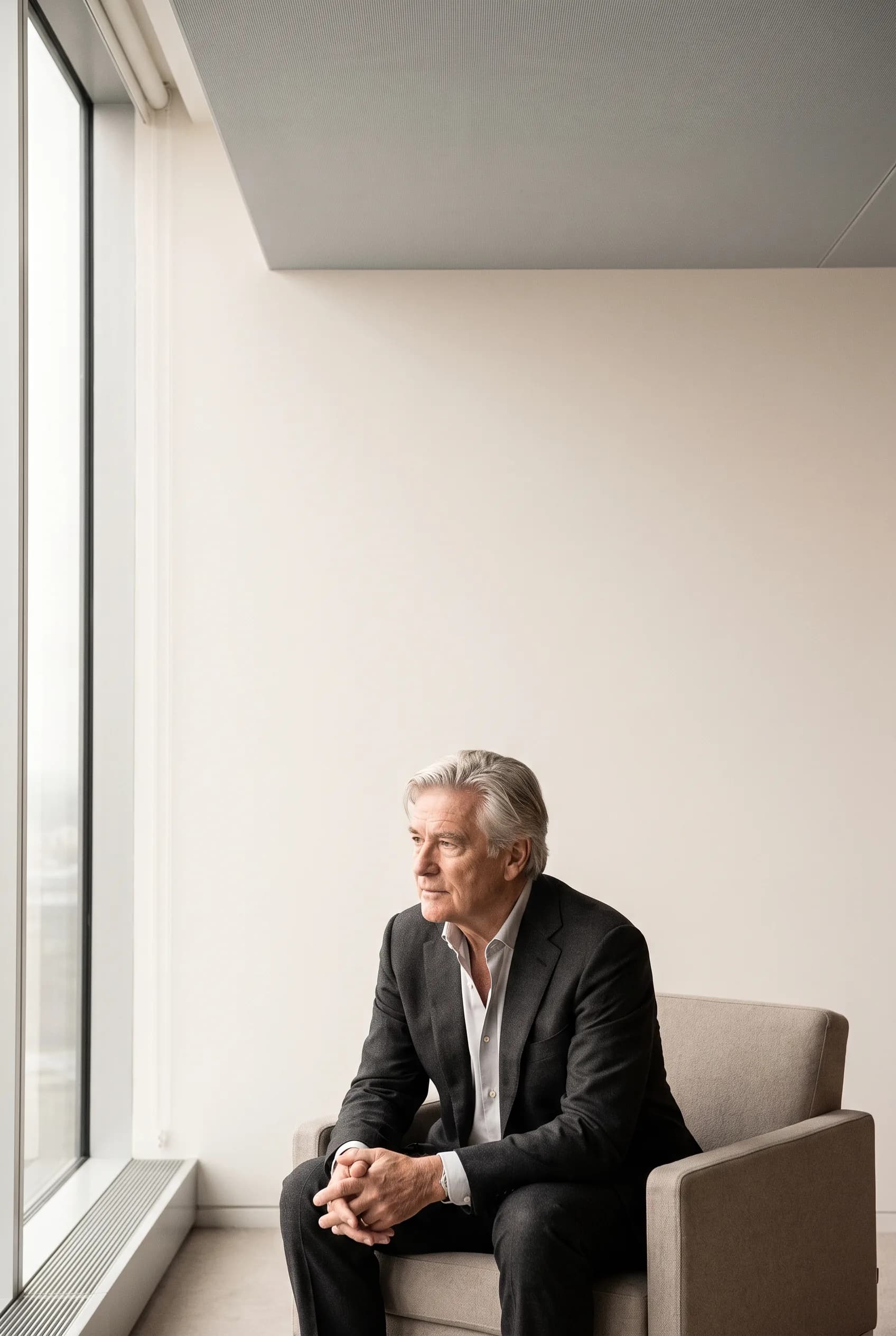 A senior executive by a window, reviewing board papers