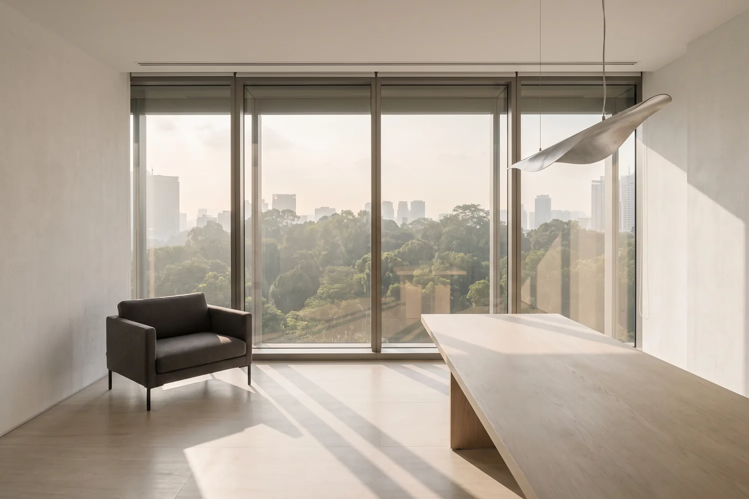 A calm, light-filled executive interior with a single chair and a long timber table